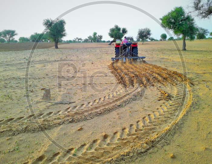 Tractor Cultivating Agriculture Land To Grow Crop In Desert Area Of India