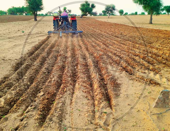 Tractor Cultivating Agriculture Land To Grow Crop In Desert Area Of India