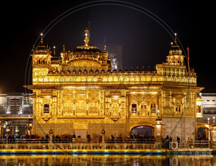 Golden Temple With Reflection In The Water At Night