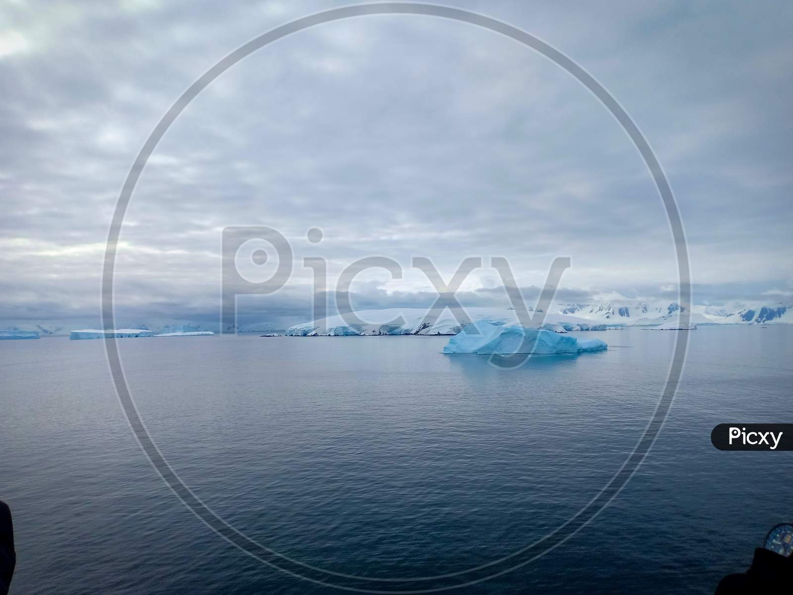 Snow covered mountain and floating iceberg in Antarctica