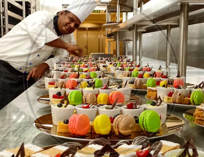 Chef posing for assorted french pastry