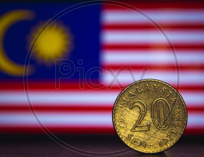 Malaysian Coin - Malaysia 20 Sen 1973 Coin Isolated On Malaysia Flag Background. Malaysian Currency Twenty Sen Coin With Space For Text Copy.