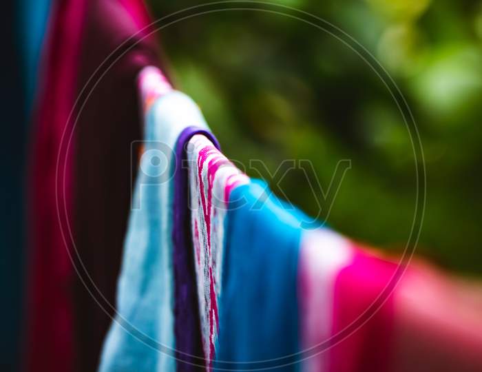 Color Clothes Dress Hanging And Drying Laundry Outside Of The Home Garden With Selective Center Focus Of The Frame.
