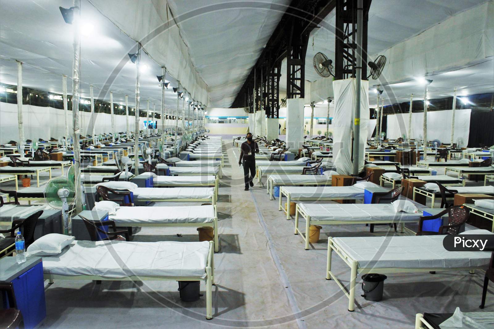 A man walks past beds in a recently constructed 1000 beds quarantine facility for patients diagnosed with the coronavirus disease (COVID-19) in Mumbai, India on June 22 2020.
