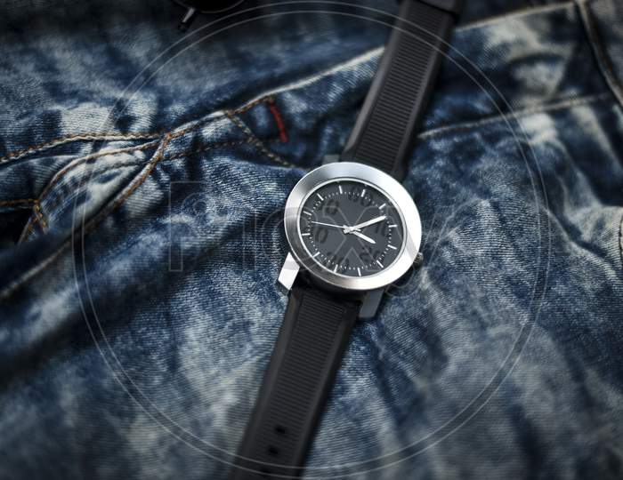 Nice luxury man's wrist watch on dark background. Stainless steel man's wrist watch with black leather strap.