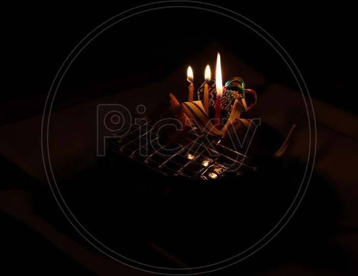 Birthday Cake Having Three Candels Lit Ina Dark Room