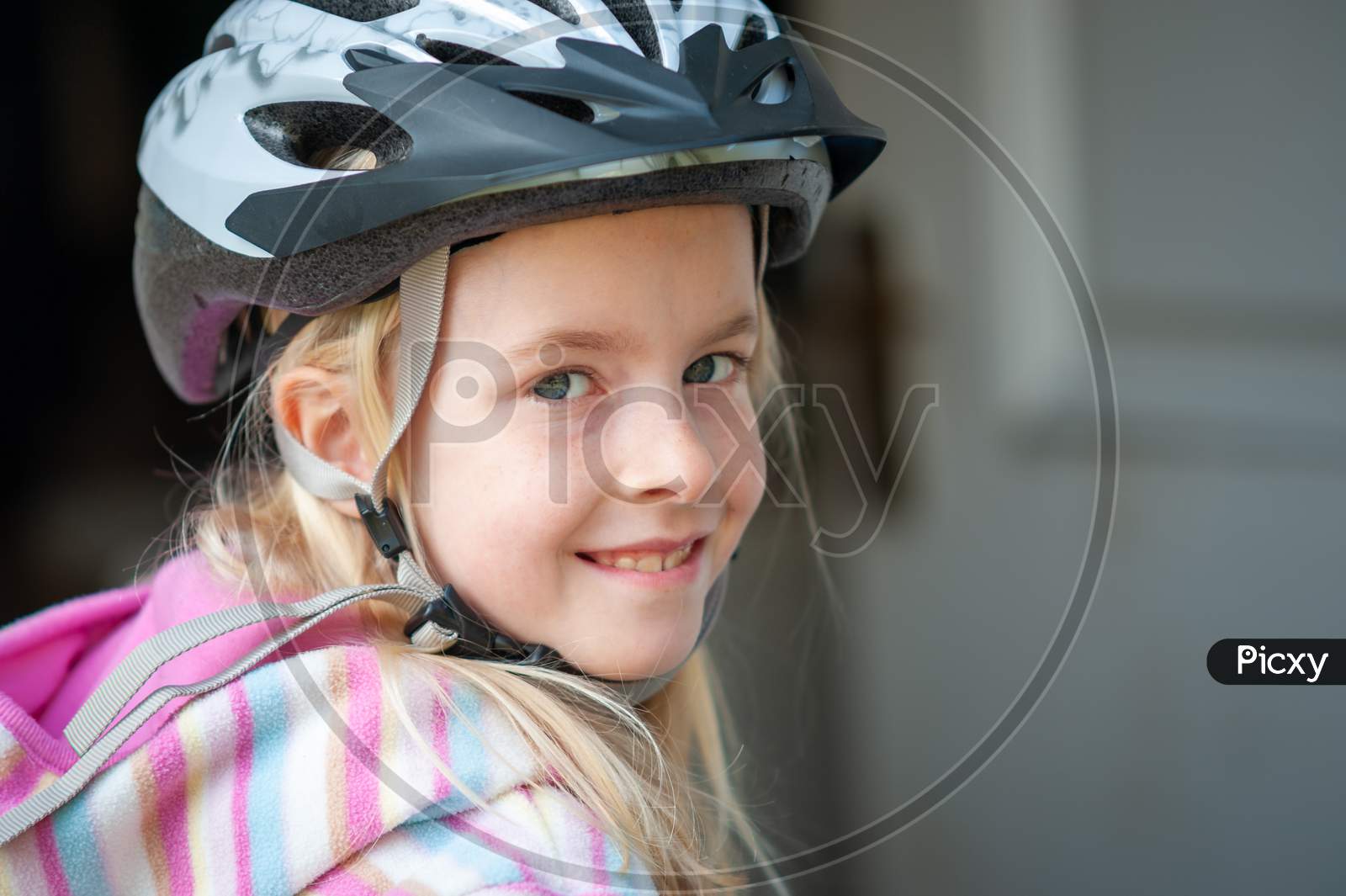 Close Up Of A Smiling Young Blonde Girl In A Cycle Helmet