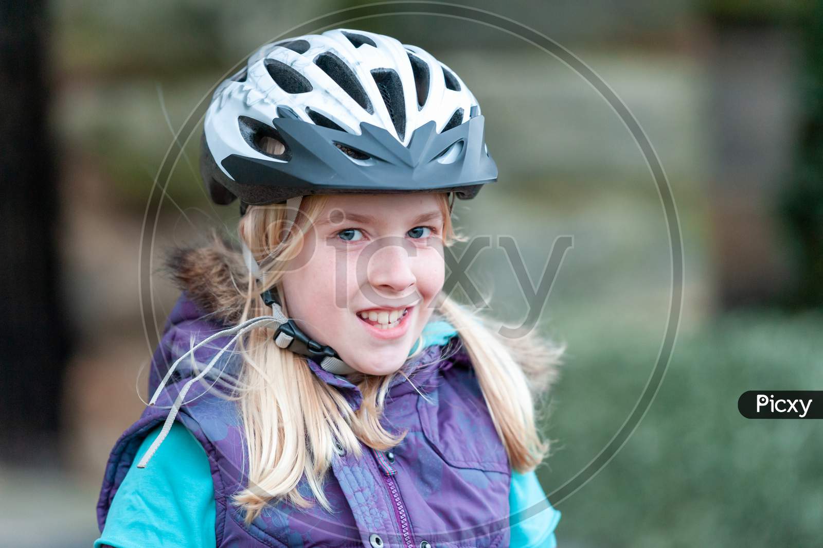 A Happy Young Blonde Girl Wears A Bike Helmet