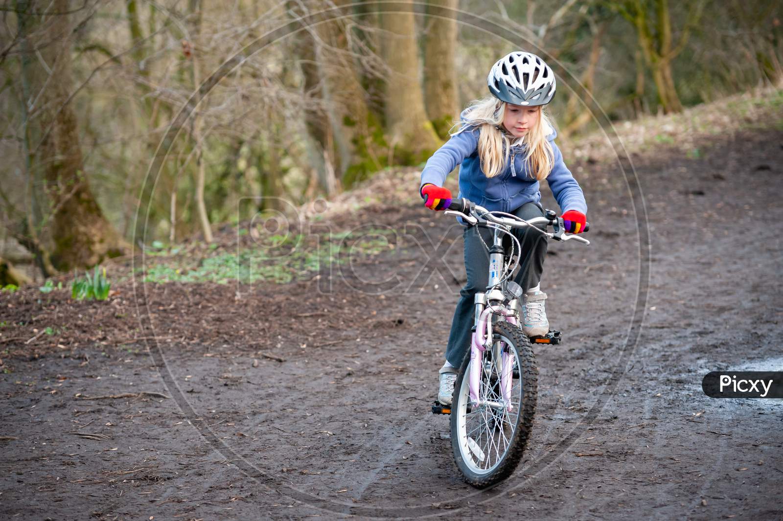 A Young Girl Riding A Bike Along A Country Track