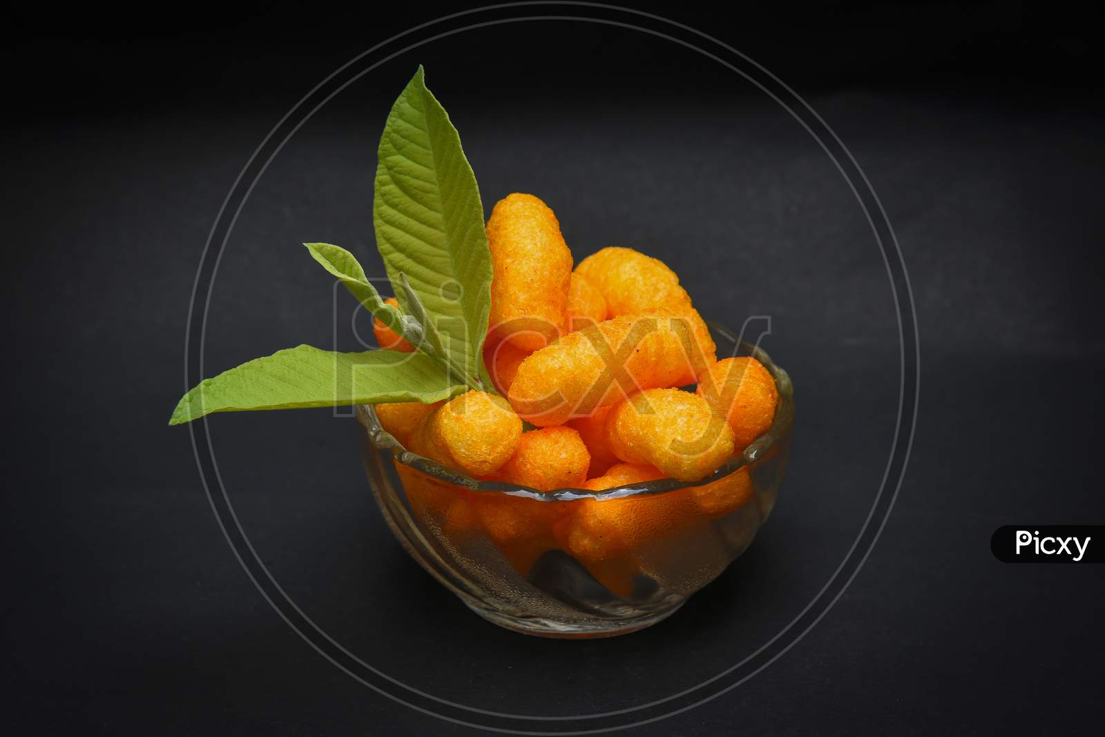 Snacks, crochets or cheese puff pastry on dark background.Different kinds of popcorn in bowl