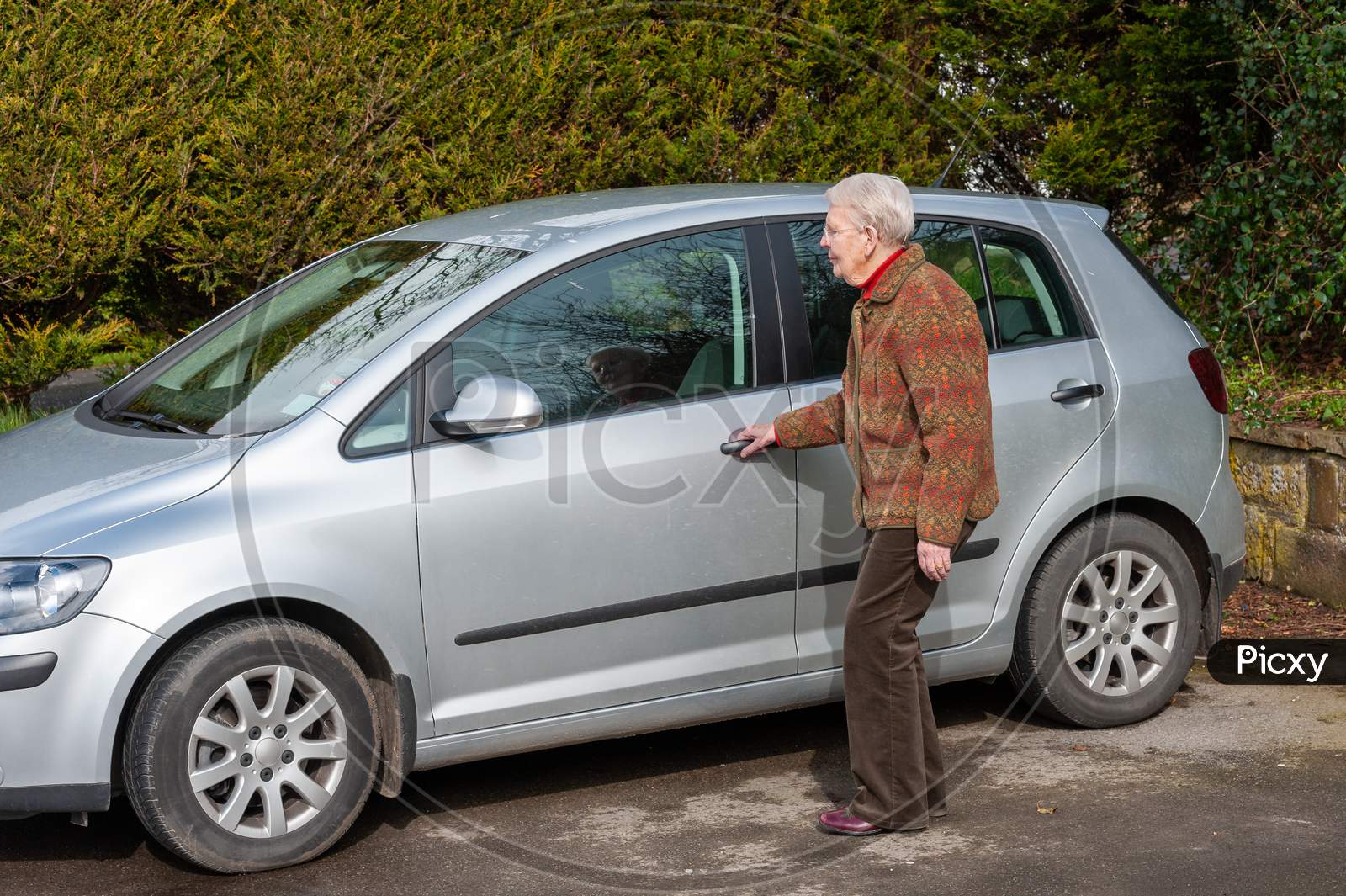 An Elderly Lady About To Open A Car Door