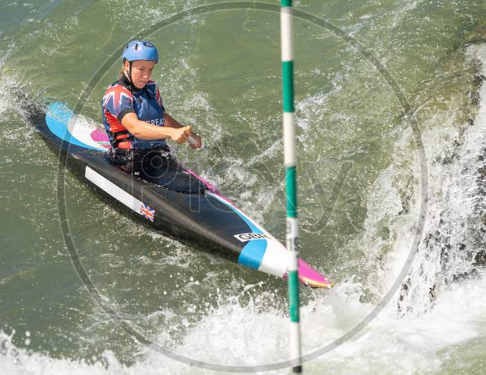 Canoe Slalom Athlete Approaches A Slalom Gate At The Bottom Of A Large Drop