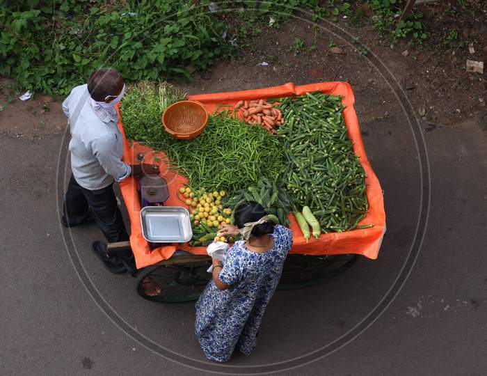 Man selling vegetables on the road while maintaining social distancing