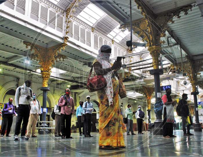 Commuters stand inside circles to maintain social distancing as they wait to board a train at a railway station after some restrictions were relaxed during the lockdown to slow the spread of the coronavirus disease (COVID-19) in Mumbai, India, June 22, 2020.