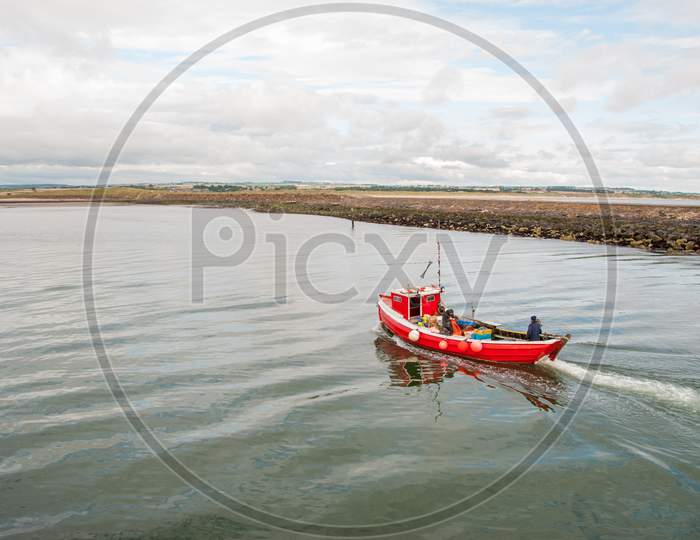 A Small Red Fishing Boat On A Calm Day