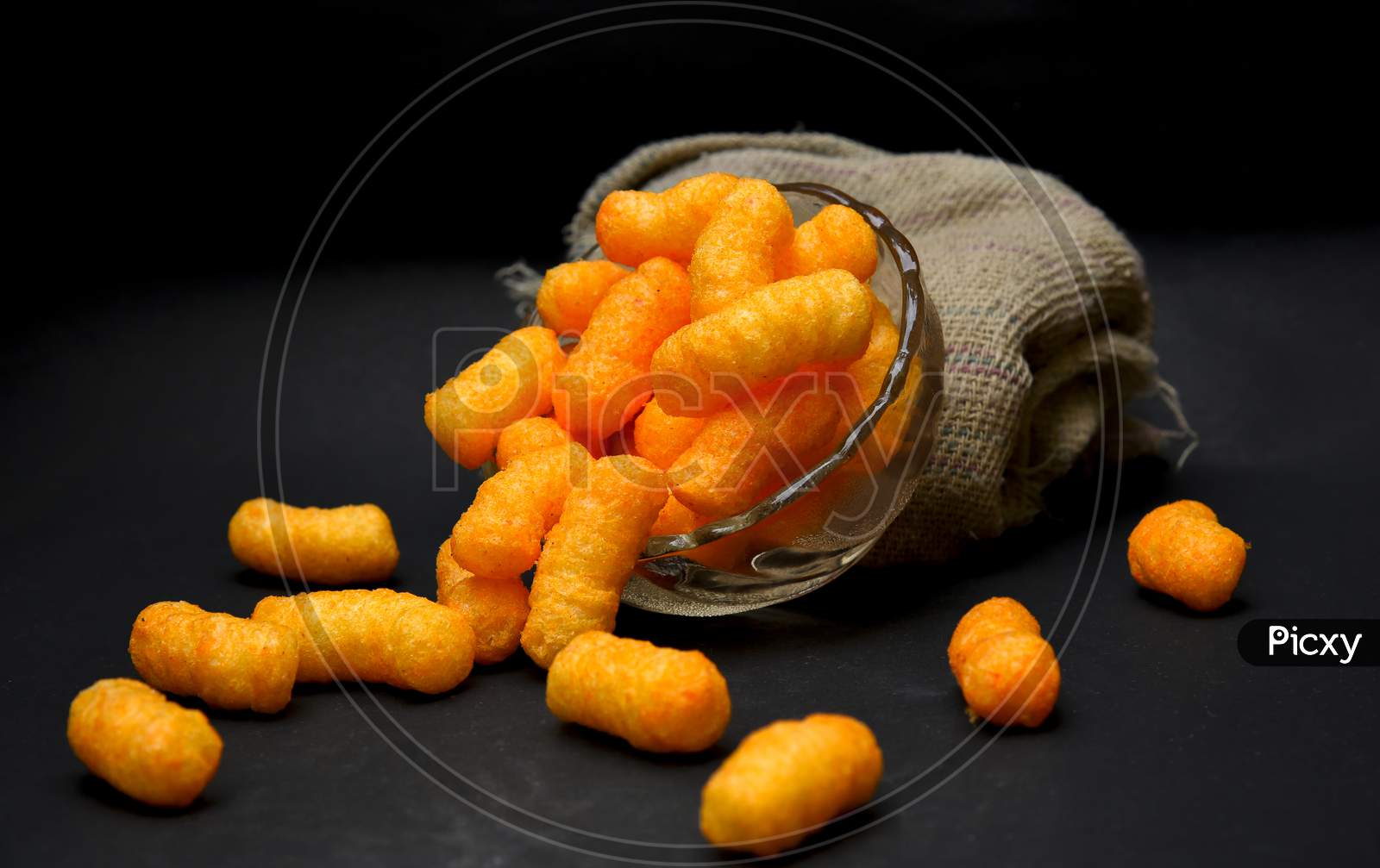 Snacks, crochets or cheese puff pastry on dark background.Different kinds of popcorn in bowl