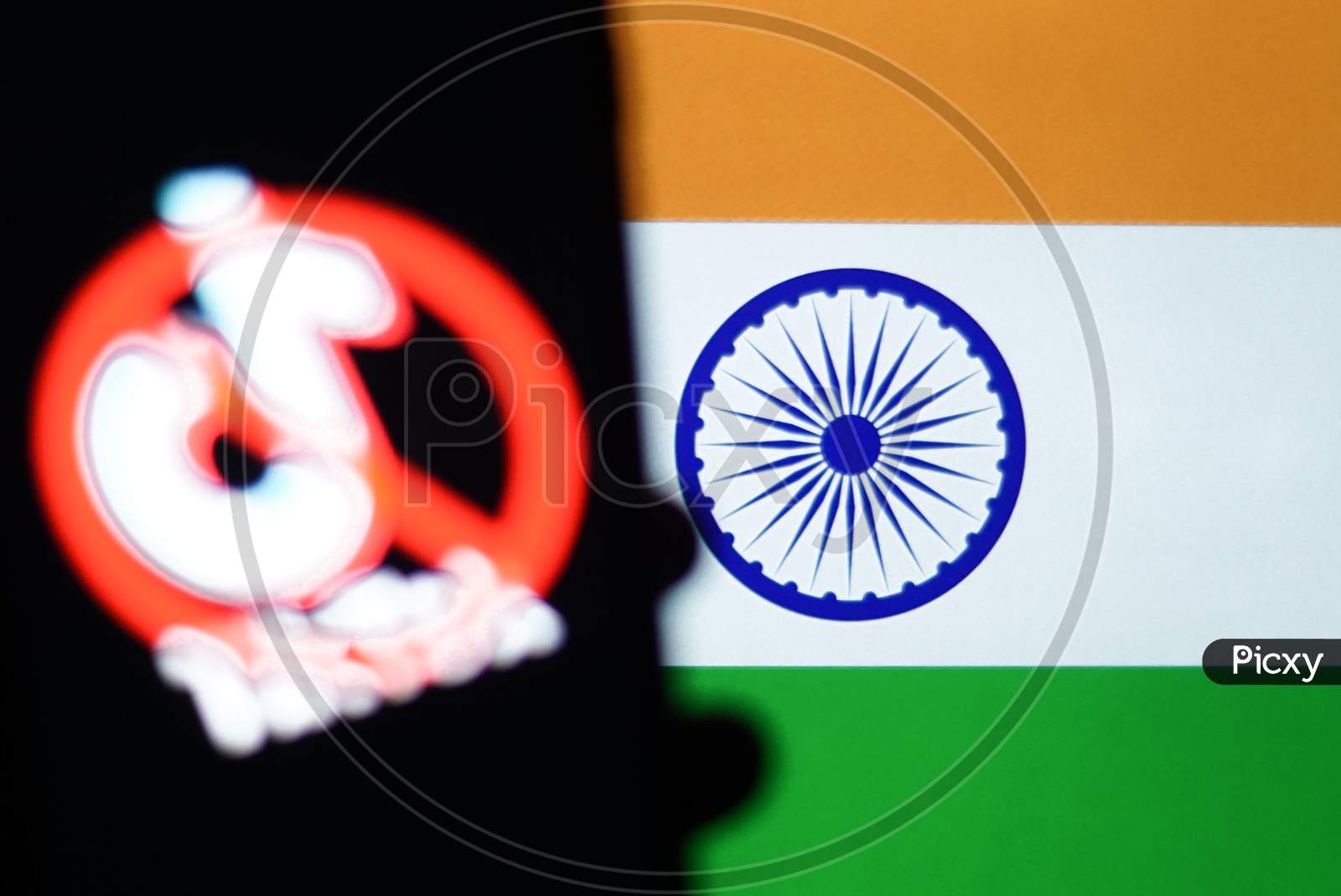 Tiktok Banned in India Application Logo On A Mobile Screen and a finger about to touch with Indian Flag in the background