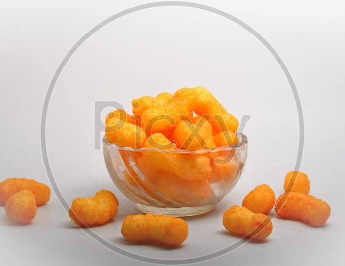 Snacks, crochets or cheese puff pastry on white background.Different kinds of popcorn in bowl
