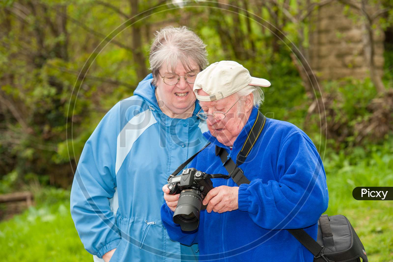An Elderly Couple Review Photographs On The Back Of A Dslr Camera
