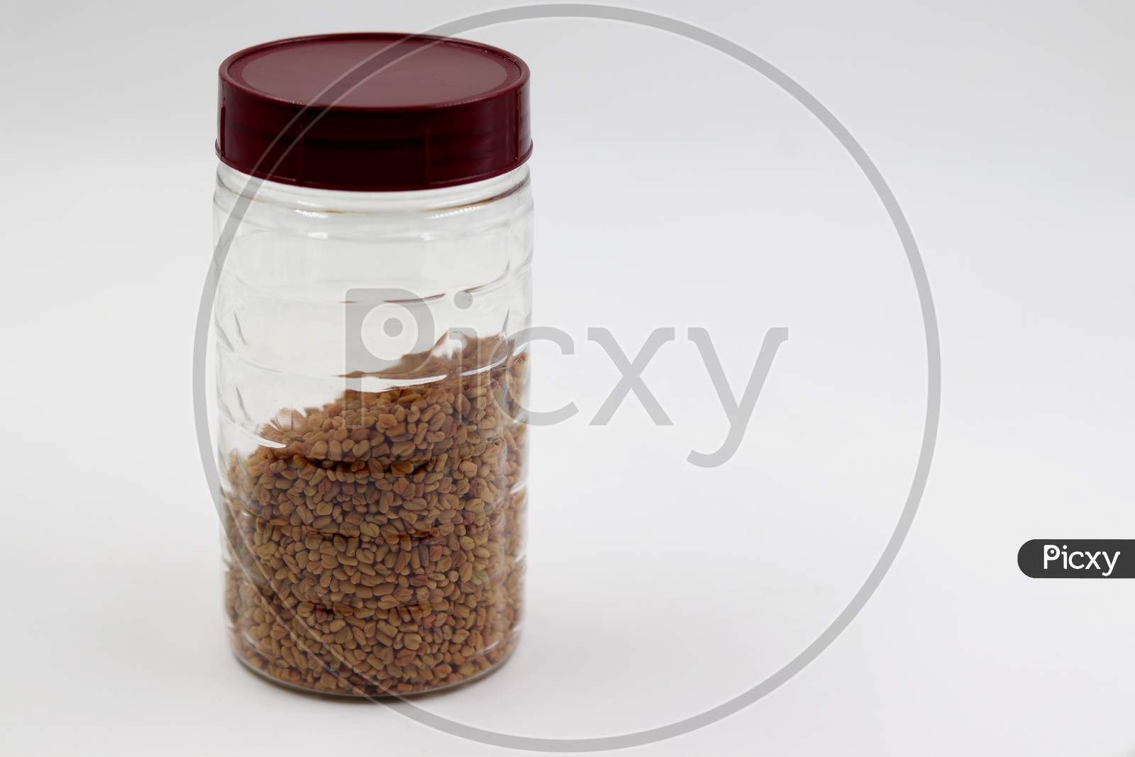 Methi Seeds in the bottle with white background