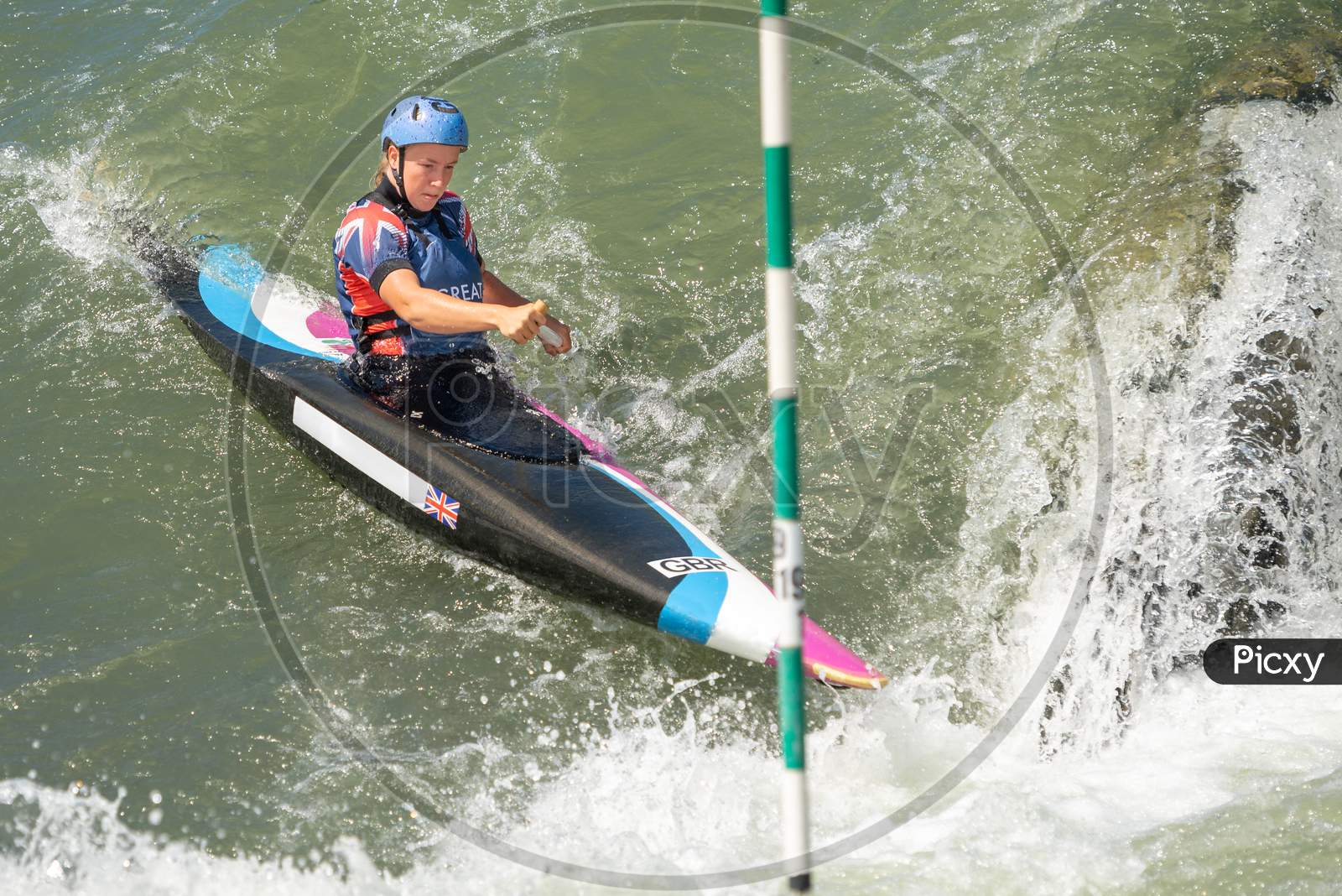 Canoe Slalom Athlete Approaches A Slalom Gate At The Bottom Of A Large Drop