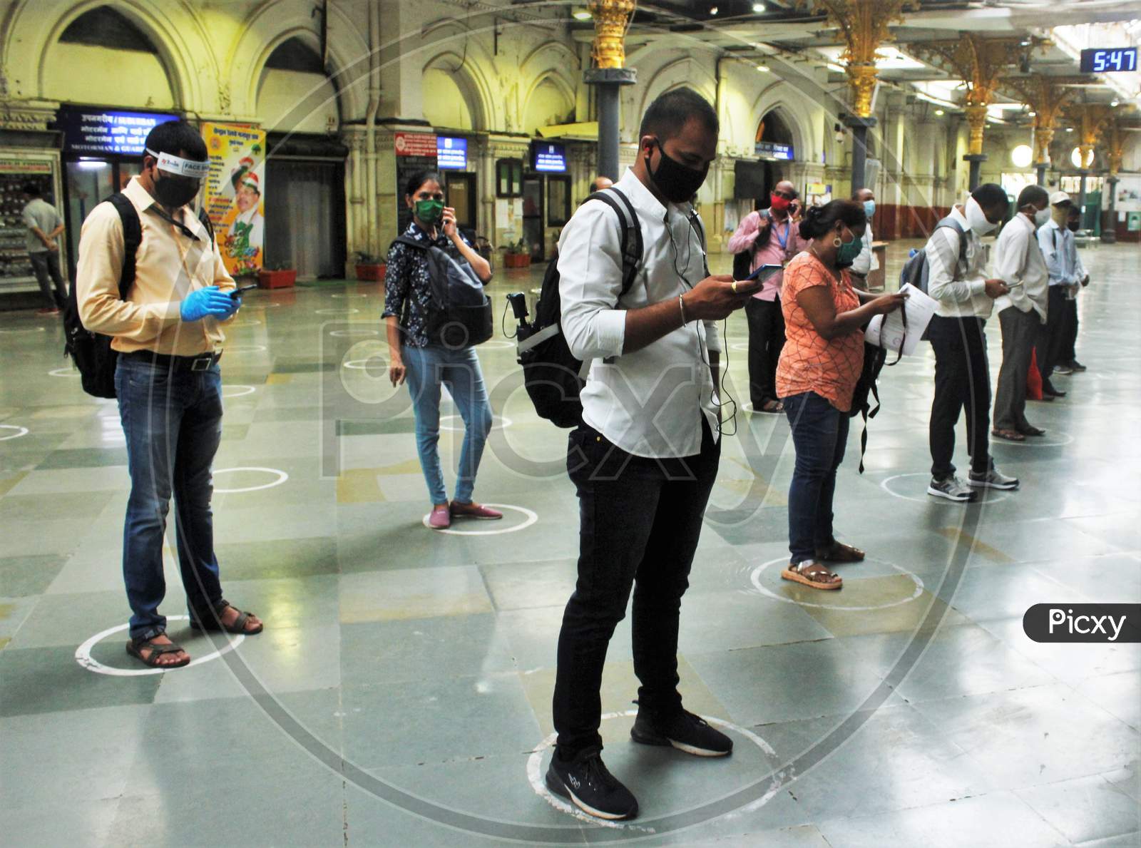 Commuters stand inside circles to maintain social distancing as they wait to board a train at a railway station after some restrictions were relaxed during the lockdown to slow the spread of the coronavirus disease (COVID-19) in Mumbai, India, June 22, 2020.