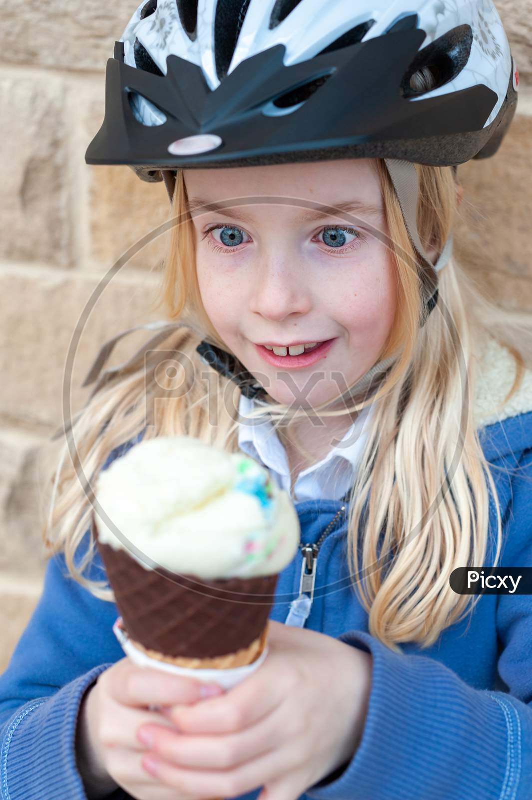 An Excited Young Blonde Girl Holds A Large Ice Cream Cone