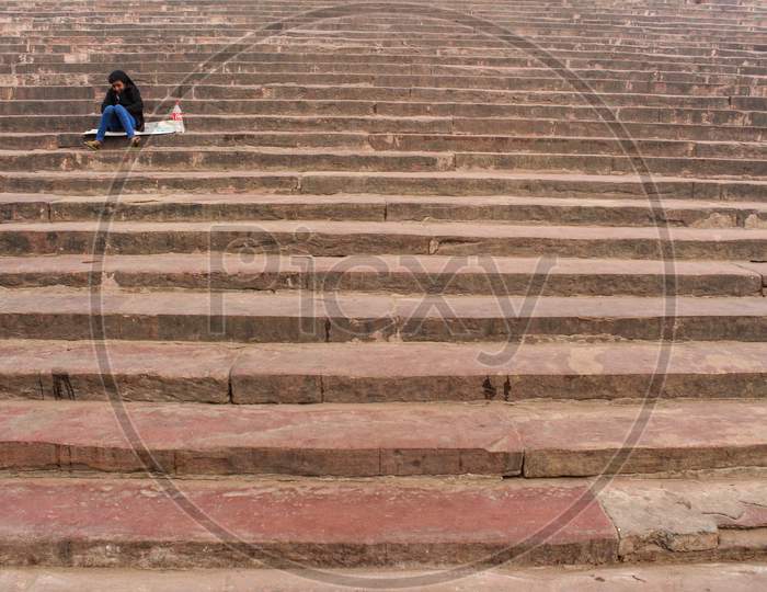 New Delhi, Delhi/ India- May 31 2020: A Little Girl Sitting Alone In A Landscape Of A Staircase.