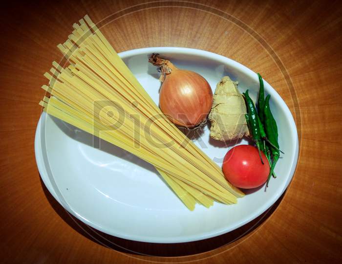 Plate of raw spaghetti and vegetables