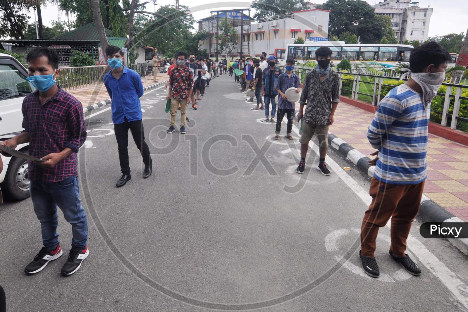 Migrants Wait In Queues To Receive cooked meals Being Distributed By The Kamrup Administration Outside The Guwahati Railway Station During Ongoing Covid-19 Lockdown, In Guwahati, Wednesday, June 3, 2020