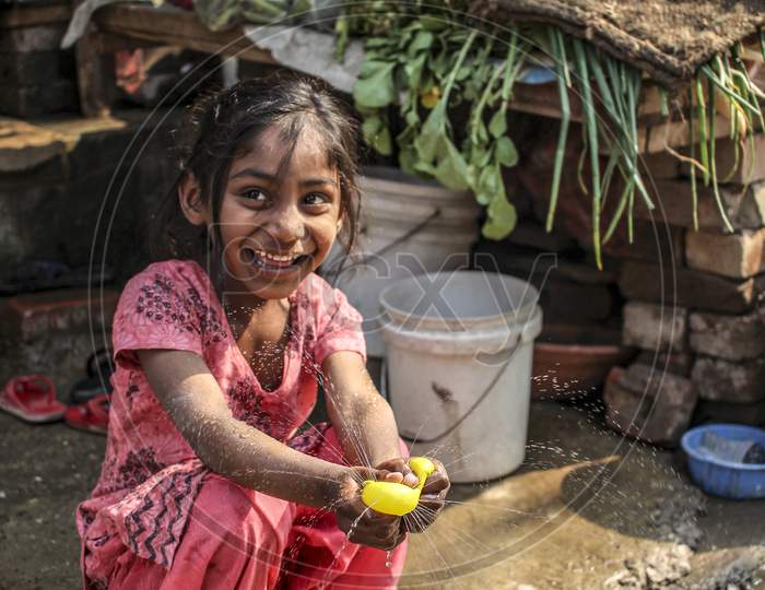 New Delhi, Delhi India- June 2 2020: A Little Girl Happily Playing With A Water Balloon, Carefree And Happy Children.