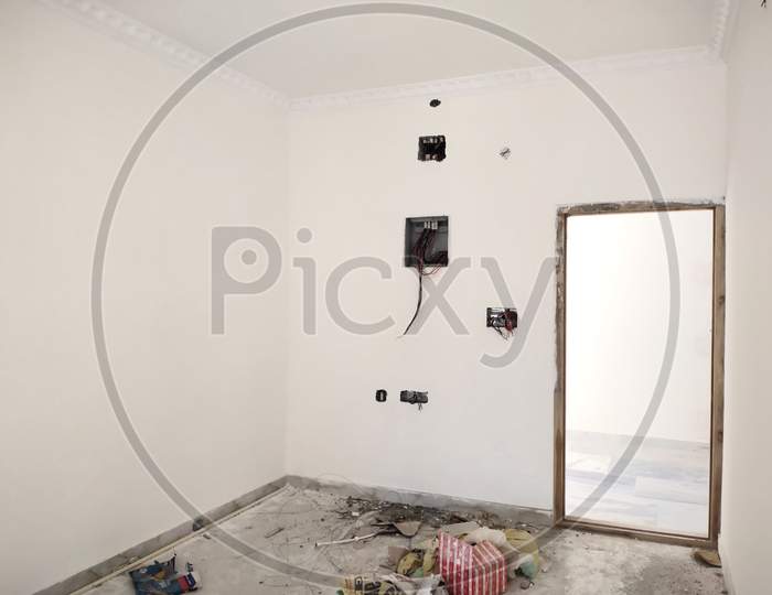 Unfinished Electrical Steel Junction Box On White Brick Wall. Household Electric Installation Work, Home Wiring Repair. Upgrade The Power System In The House.Wires, Switch Box And Socket On Wall.