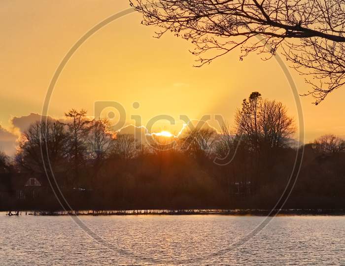 Beautiful and romantic sunset at a lake in yellow and orange colors