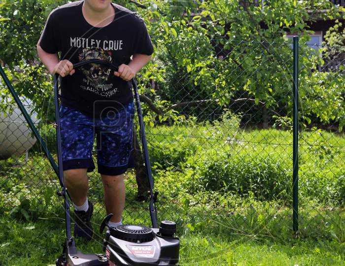 Teenage Boy Mowing Grass