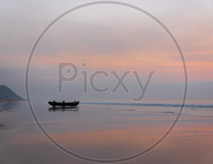 fishermen carrying a boat into the sea