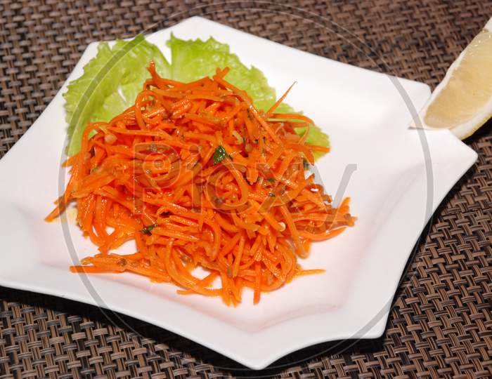 Korean Carrot Salad With Lemon On The White Plate