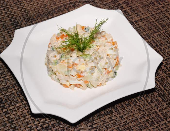 Russian Salad Olivie Served On The White Plate