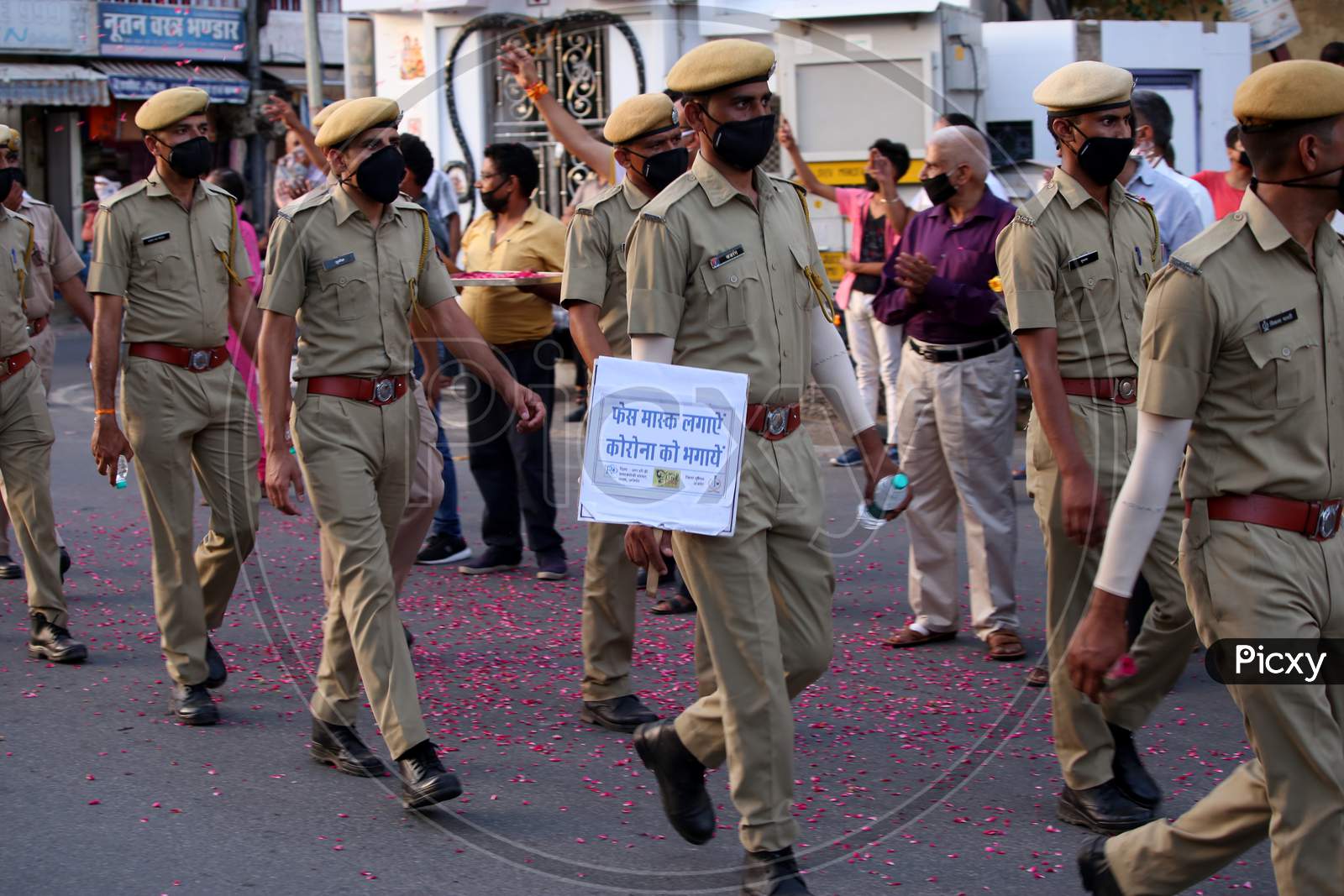 Police officers hold banners in a flag march organised to spread awareness on Covid-19 during a lockdown in Ajmer, Rajasthan