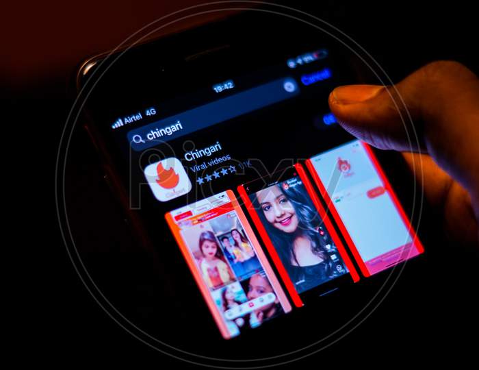 Chingari App logo on Mobile screen with a finger about to Download the App
