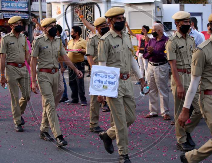 Police officers hold banners in a flag march organised to spread awareness on Covid-19 during a lockdown in Ajmer, Rajasthan