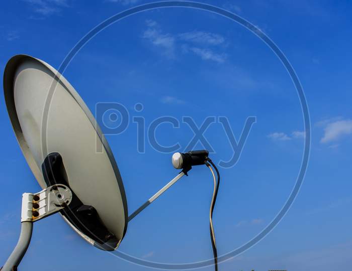 White Satellite Antenna With Blue Sky And White Clouds Background