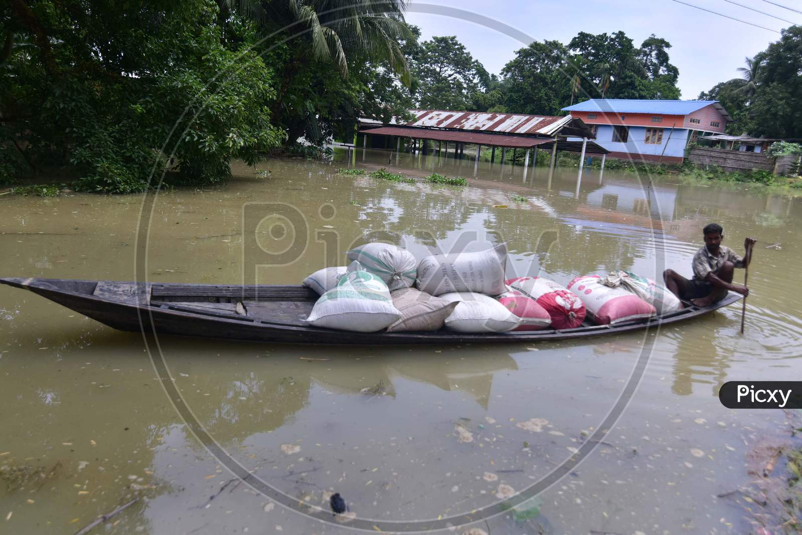 A Flood Affected Villager Transports Sacks Of Rice Towards A Safer Place At  Mayong  In Morigaon District Of Assam On June 29, 2020.