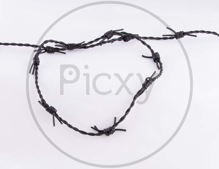 Black Barbed Wire Closeup on white background with copy space