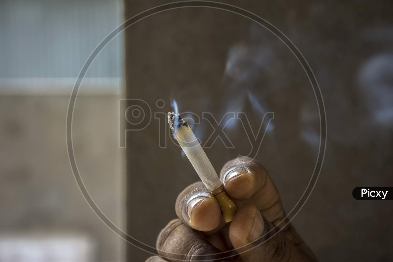 White Burning Cigarette With Smoke In A Hand