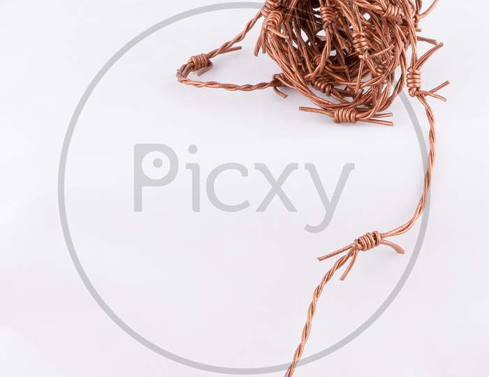 Copper Barbed Wire Closeup on white background with copy space