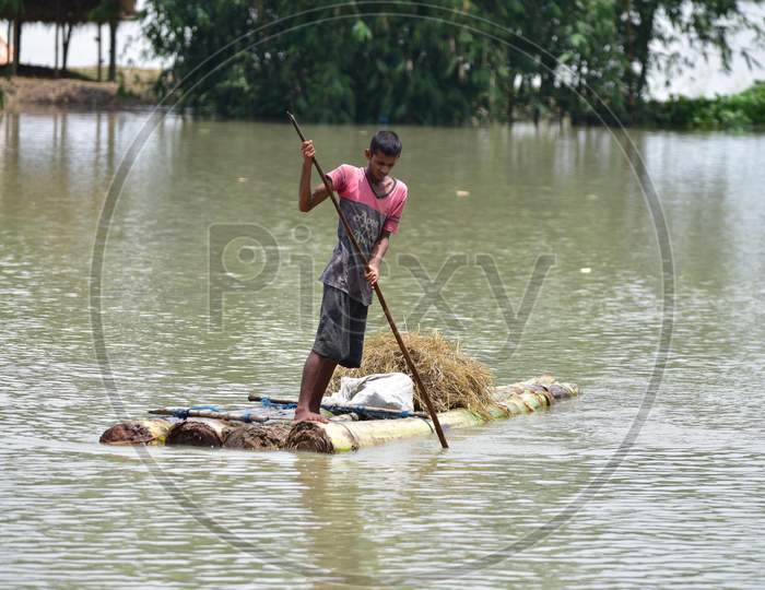 A Boy wades through floodwaters on a Makeshift Raft In Morigaon District, In The Northeastern State Of Assam  On June 29,2020