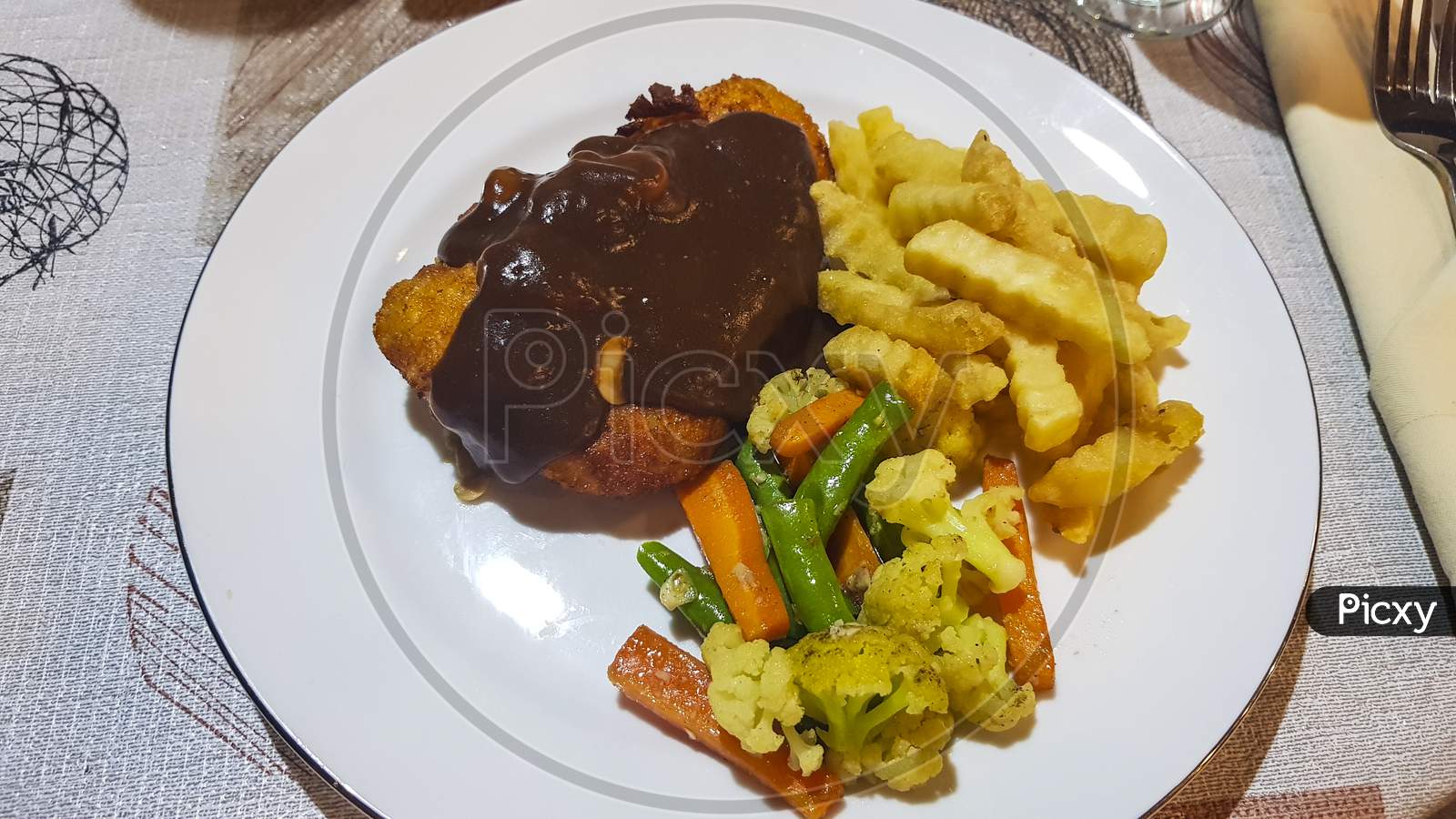 Chicken Chops In Sauce. Fried Potatoes With Vegetables.