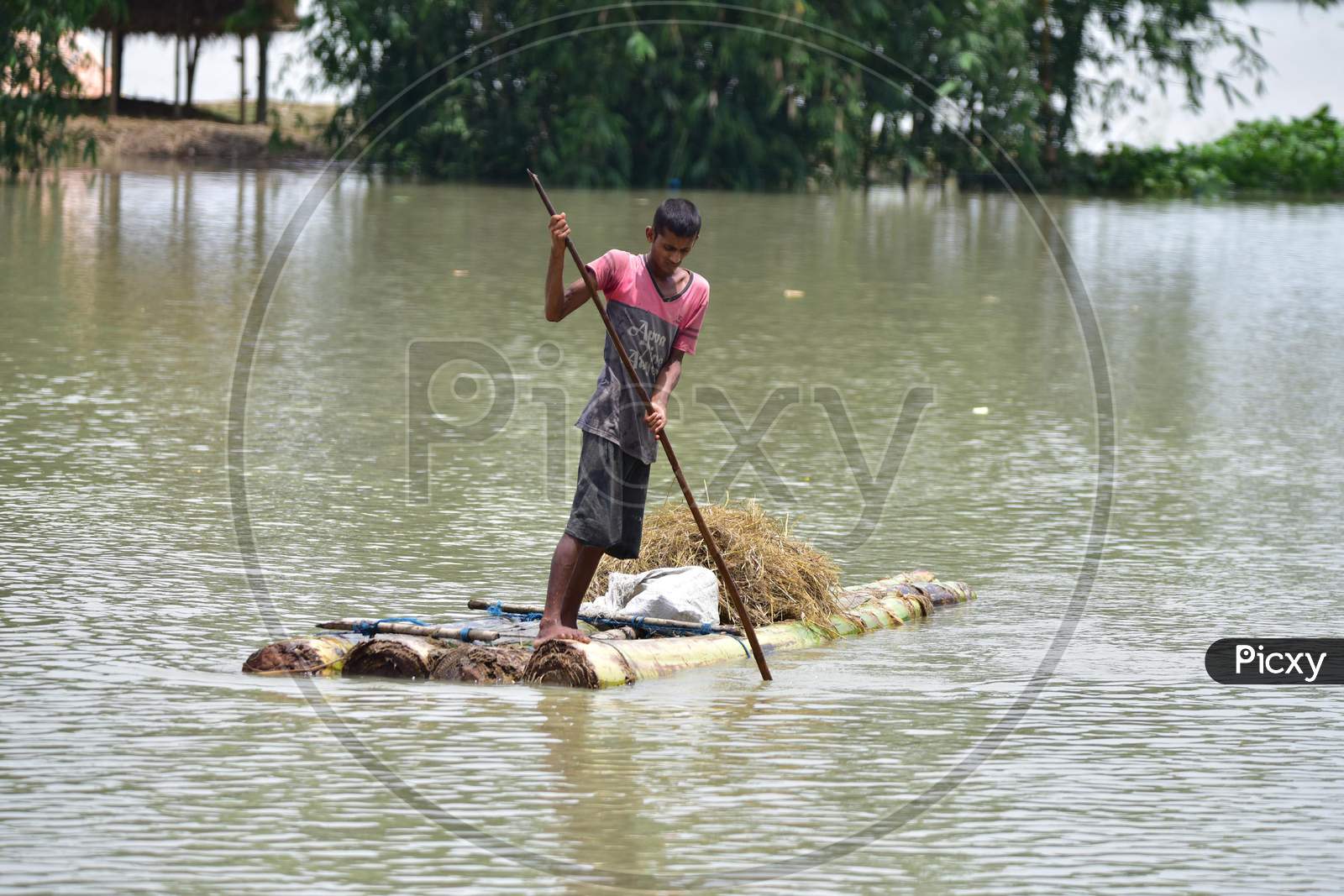 A Boy wades through floodwaters on a Makeshift Raft In Morigaon District, In The Northeastern State Of Assam  On June 29,2020