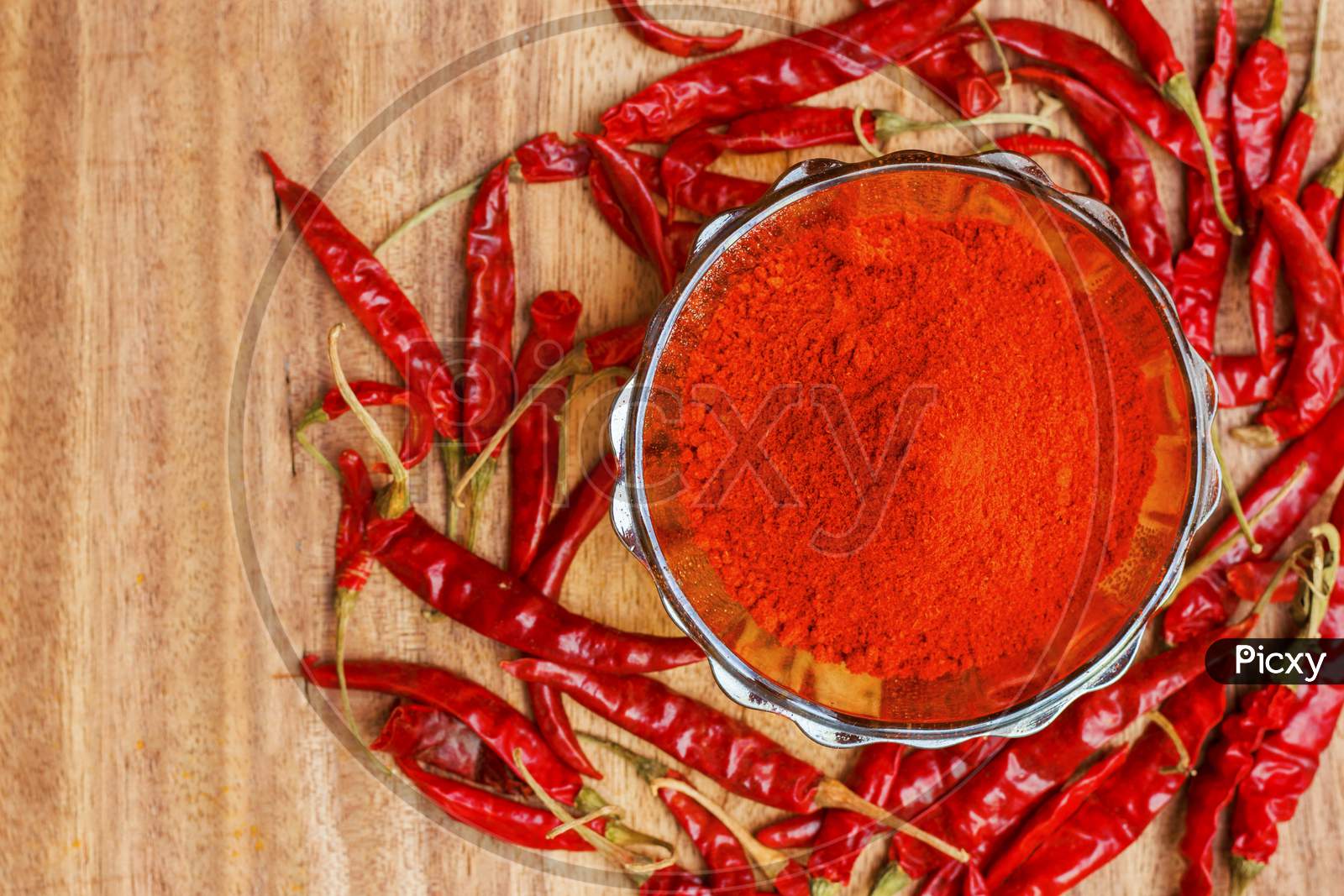 dry red chilli powder with wooden background