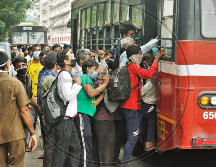 People scramble to enter a public bus, after the government eased a nationwide lockdown that was imposed as a preventive measure against the COVID-19 coronavirus, in Mumbai, India, on June 26, 2020.